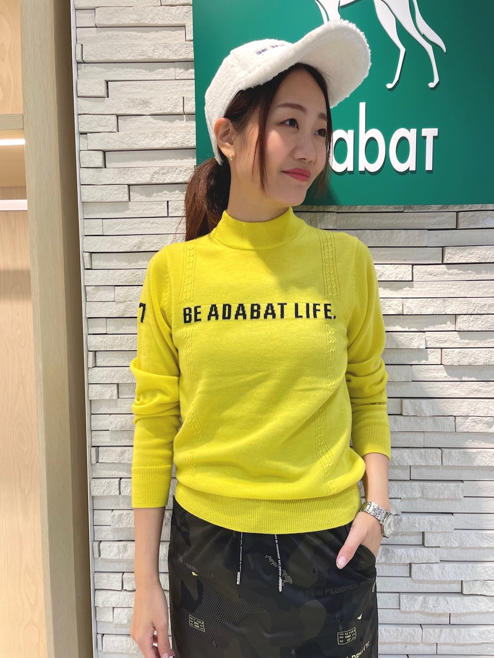 グリーン系のスカート、グリーン系のボストンバッグ、イエロー系のニット/セーターを着用したレディースの秋コーディネートの4枚目の写真