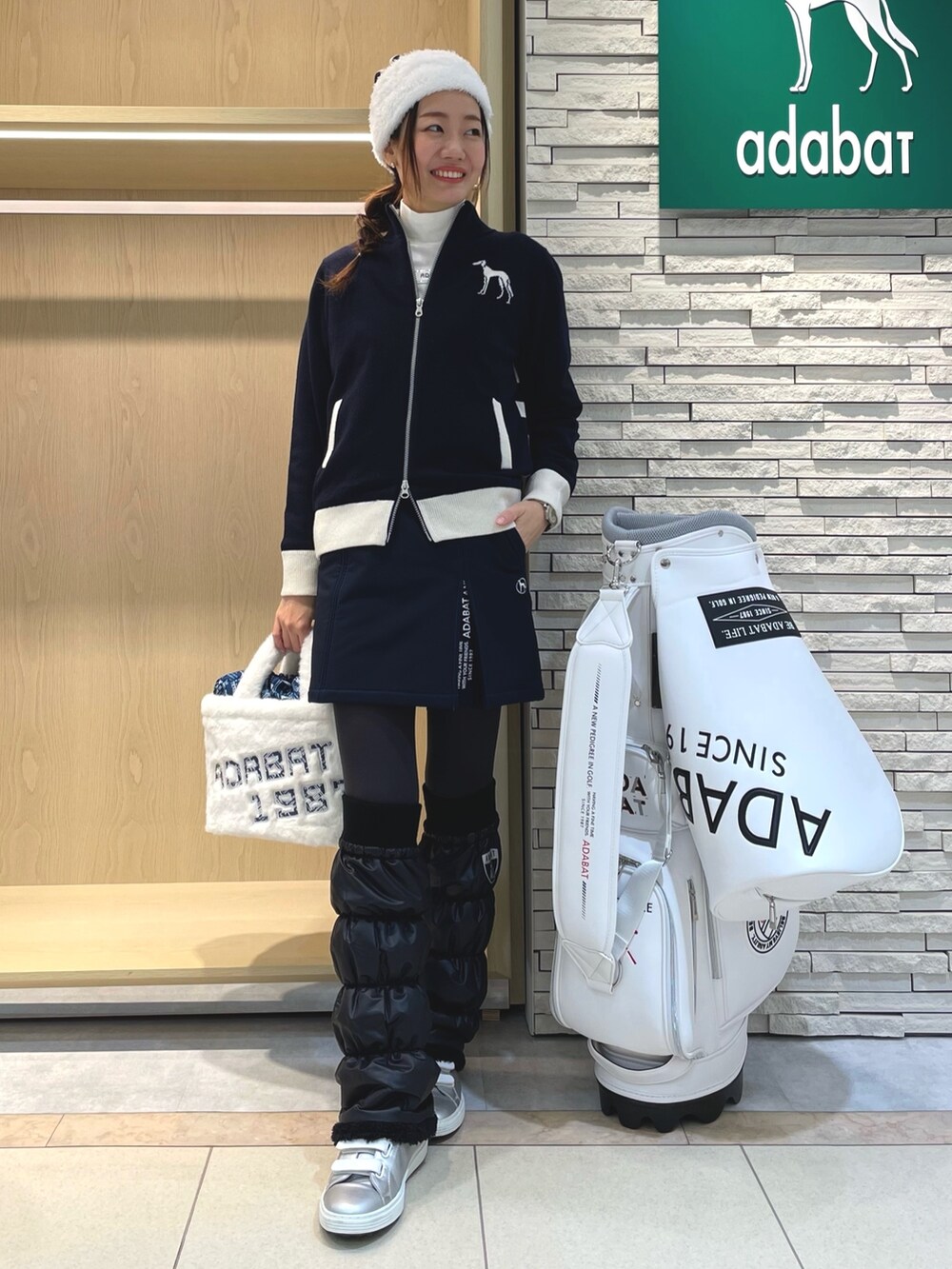 ブルー系のスカート、ホワイト系のハンドバッグ、ブルー系のニット/セーターを着用したレディースの冬コーディネートの2枚目の写真