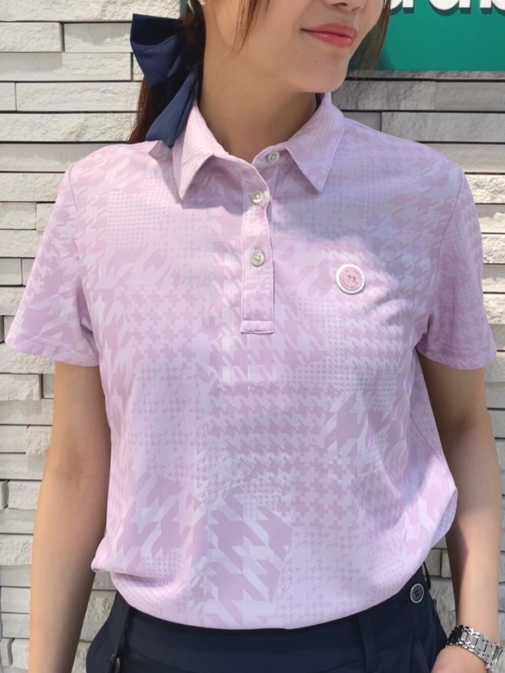 ピンク系のポロシャツ、ブルー系のスカート、ホワイト系のキャップを着用したレディースの夏コーディネートの4枚目の写真