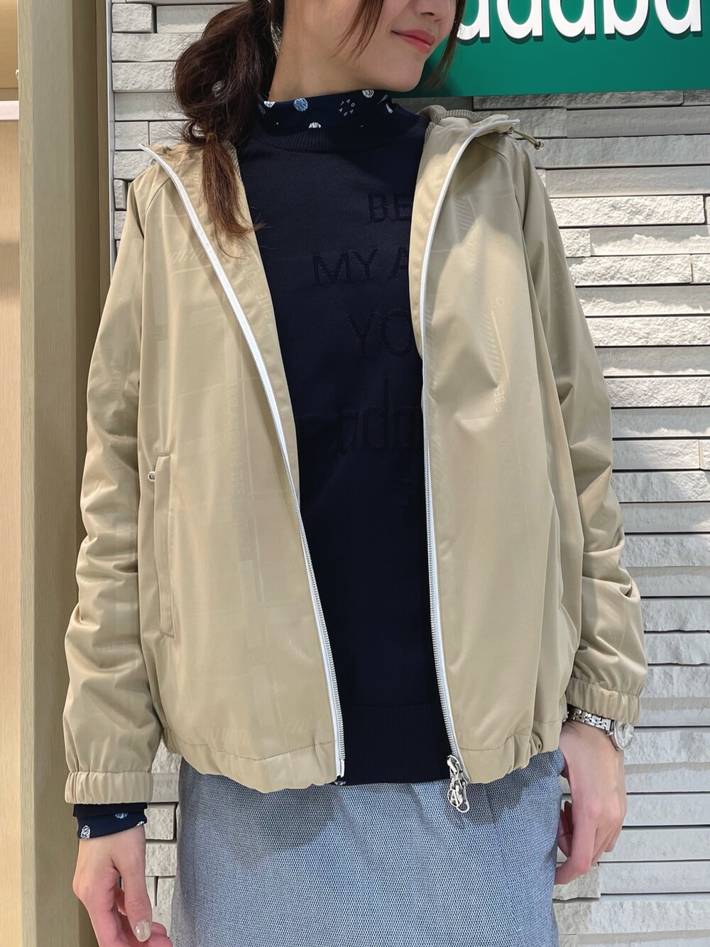 ブルー系のスカート、ベージュ系のブルゾン、ブルー系のニット/セーターを着用したレディースの春コーディネートの4枚目の写真