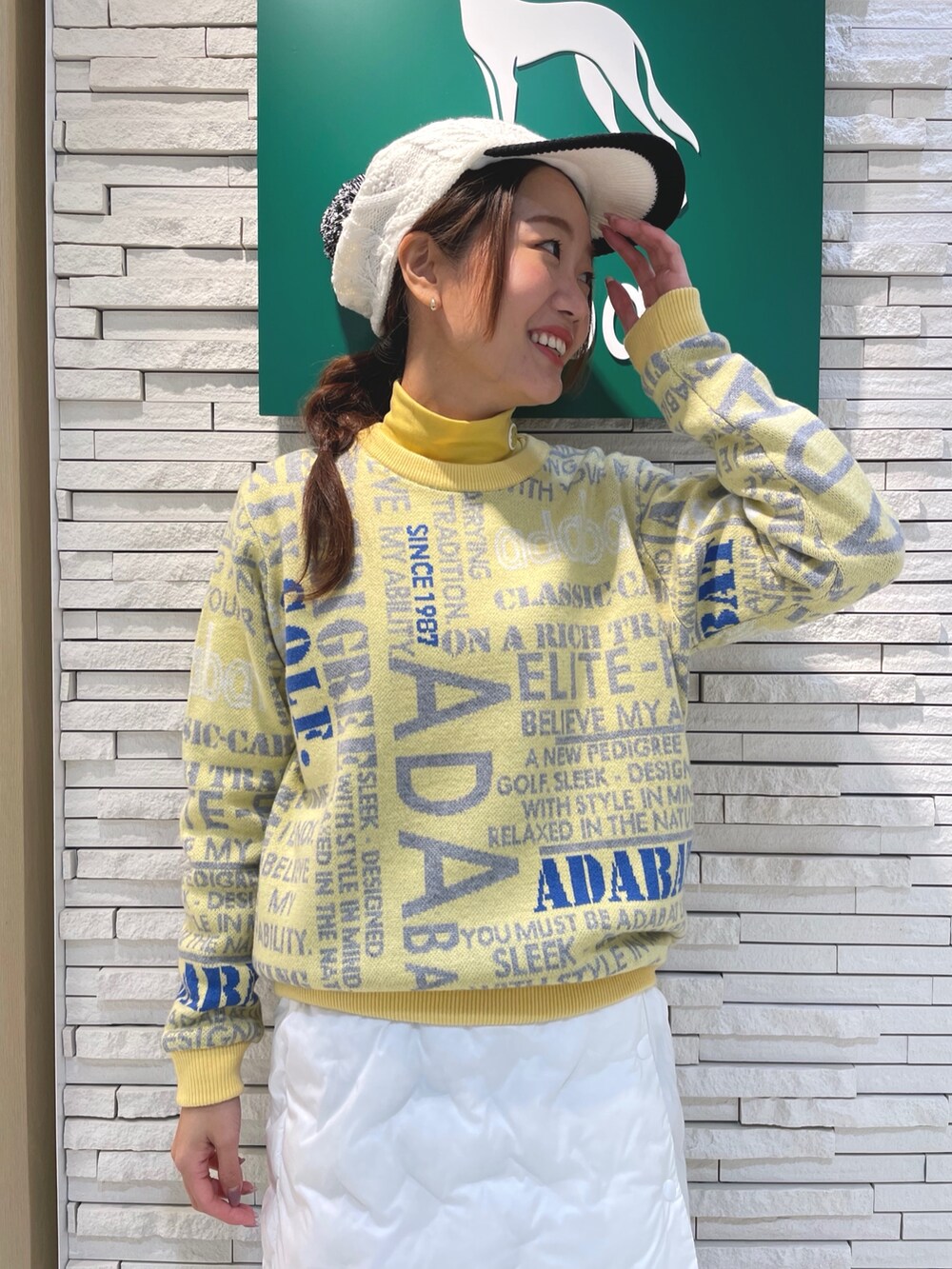 ホワイト系のスカート、イエロー系のニット/セーター、ホワイト系のハンドバッグを着用したレディースの冬コーディネートの4枚目の写真