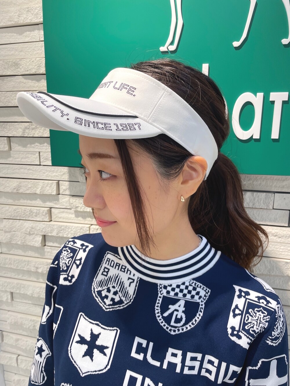 ブルー系のワンピース、ホワイト系のハンドバッグ、ホワイト系のサンバイザーを着用したレディースの秋コーディネートの3枚目の写真