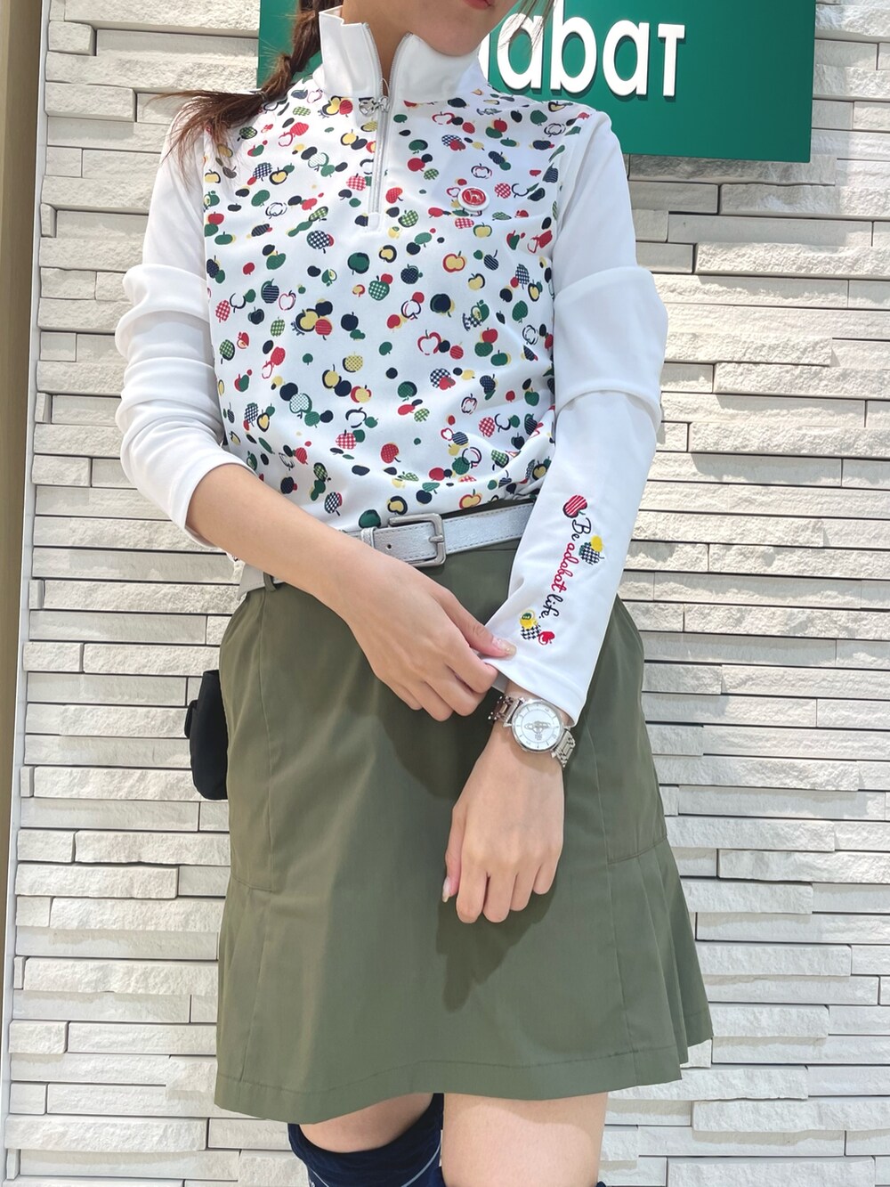 グリーン系のスカート、レッド系のTシャツ/カットソー、ブラック系のハンドバッグを着用したレディースの秋コーディネートの4枚目の写真