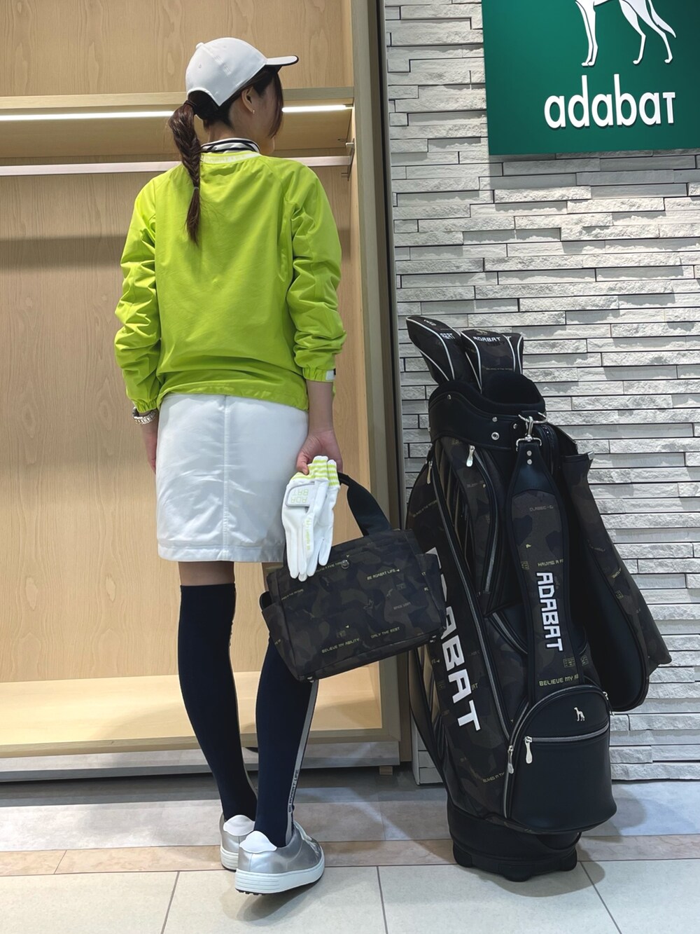 グリーン系のスカート、イエロー系のブルゾン、ホワイト系のTシャツ/カットソーを着用したレディースの冬コーディネートの3枚目の写真