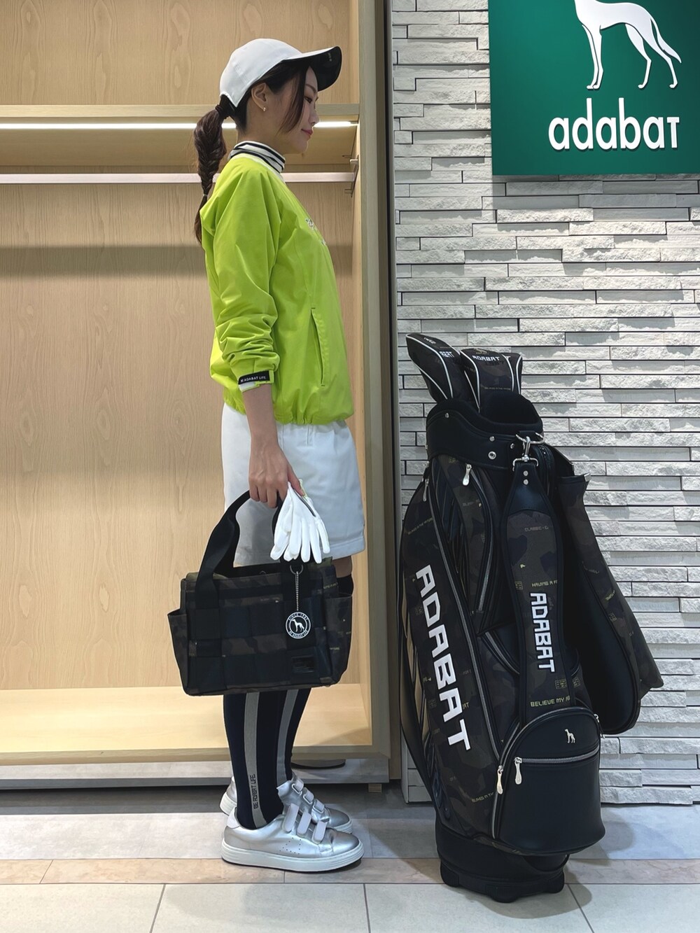 グリーン系のスカート、イエロー系のブルゾン、ホワイト系のTシャツ/カットソーを着用したレディースの冬コーディネートの2枚目の写真