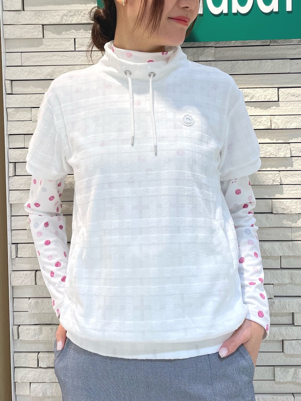 ブルー系のスカート、ホワイト系のベスト、ピンク系のTシャツ/カットソーを着用したレディースの春コーディネートの2枚目の写真