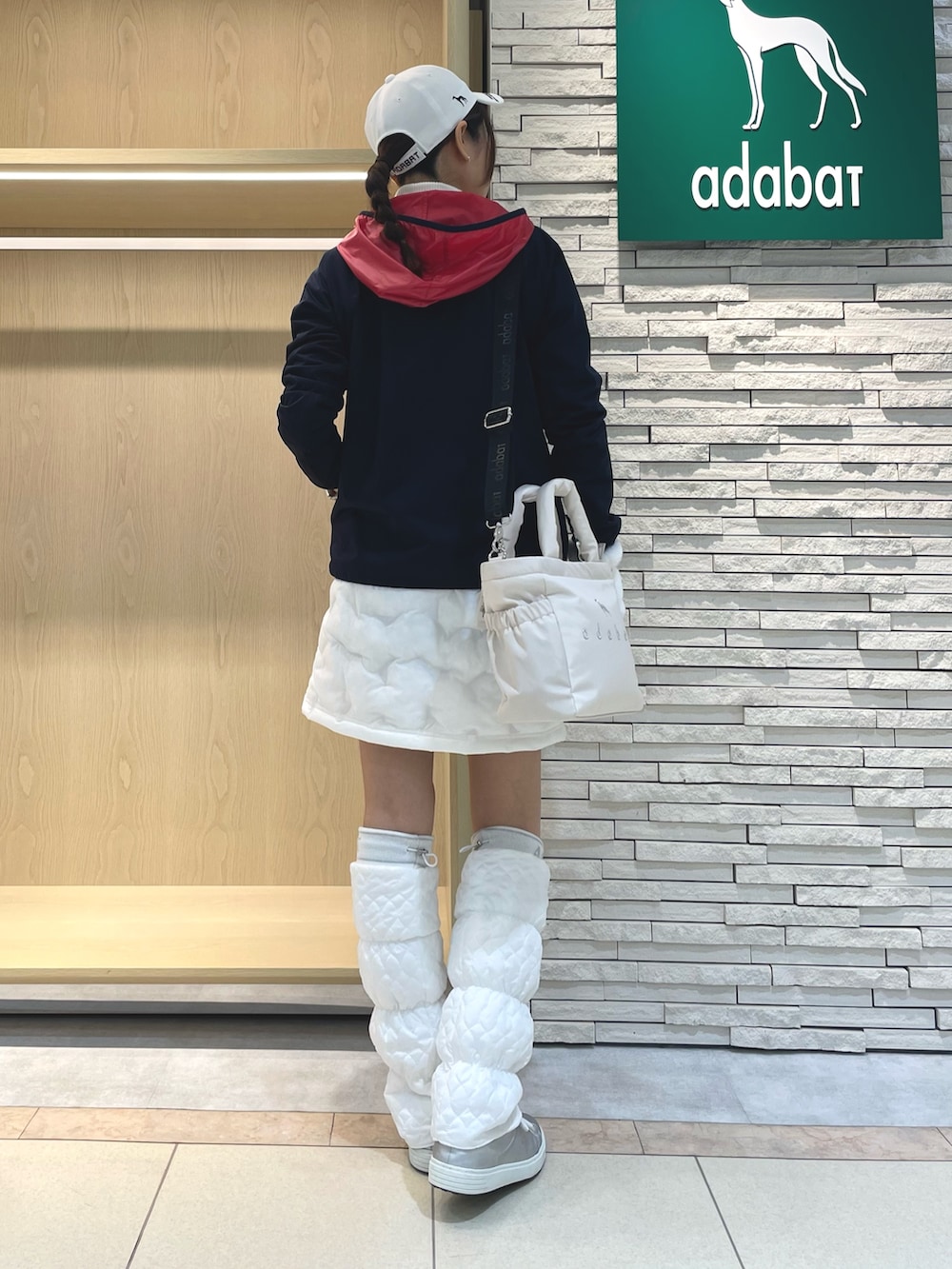 ブルー系のブルゾン、ホワイト系のスカート、ホワイト系のハンドバッグを着用したレディースの冬コーディネートの3枚目の写真