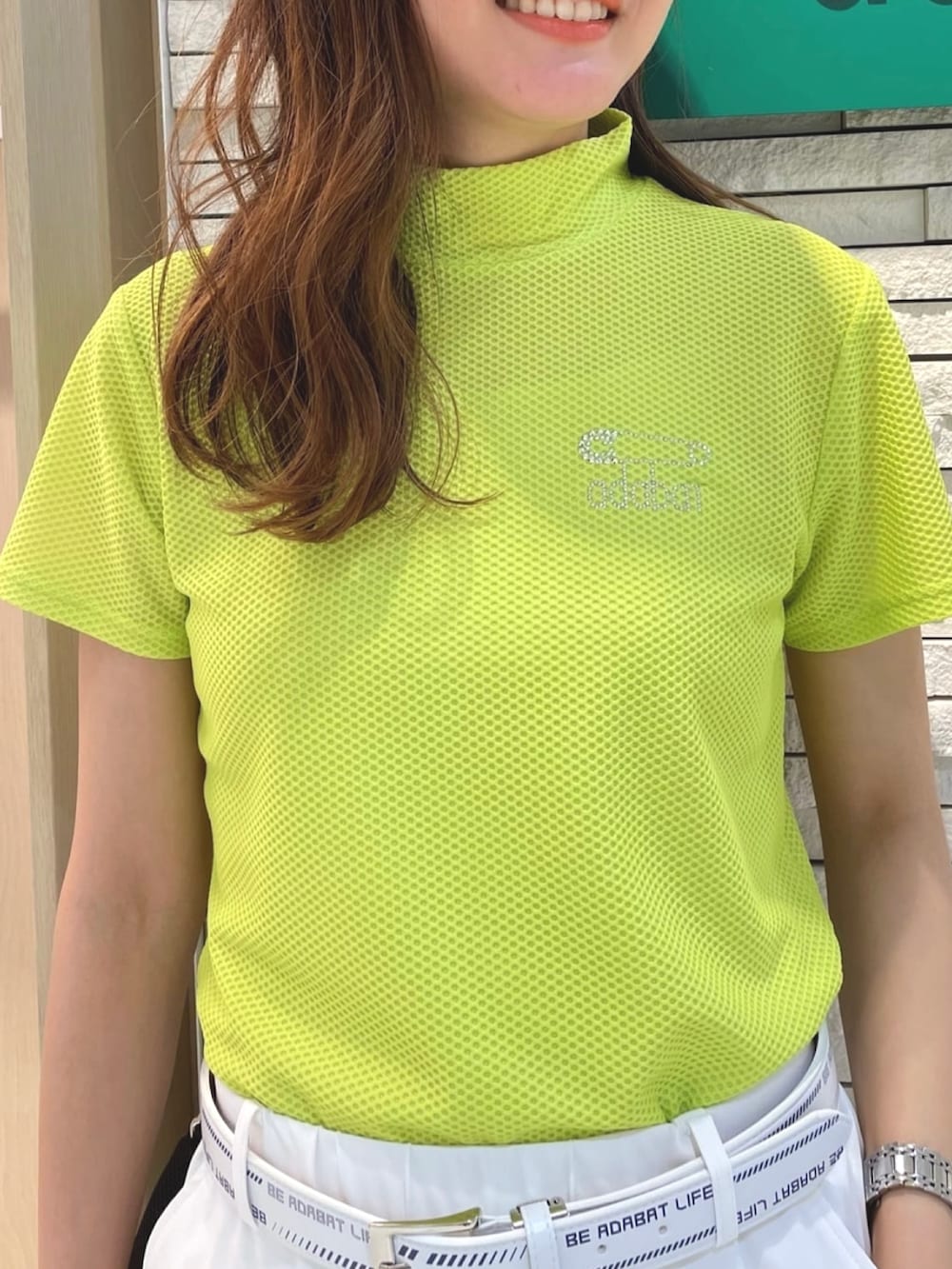 ホワイト系のスニーカー、ブルー系のハンドバッグ、イエロー系のTシャツ/カットソーを着用したレディースの夏コーディネートの3枚目の写真