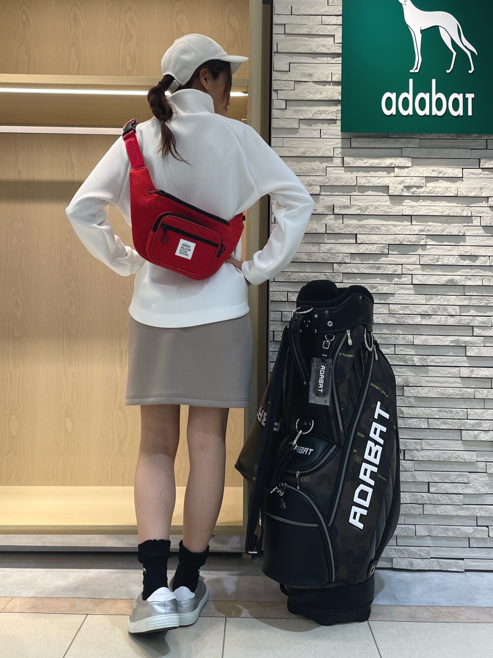 ホワイト系のTシャツ/カットソー、ベージュ系のスカート、レッド系のボディバッグ/ウエストポーチを着用したレディースの秋コーディネートの3枚目の写真