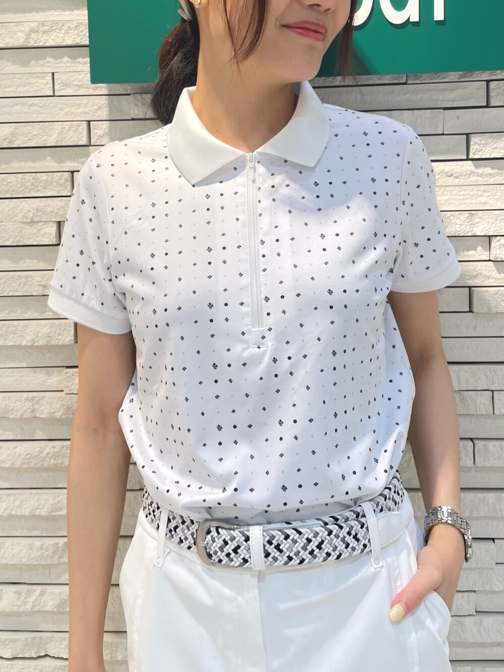 ホワイト系のポロシャツ、ホワイト系のスカート、ホワイト系のトートバッグを着用したレディースの夏コーディネートの4枚目の写真