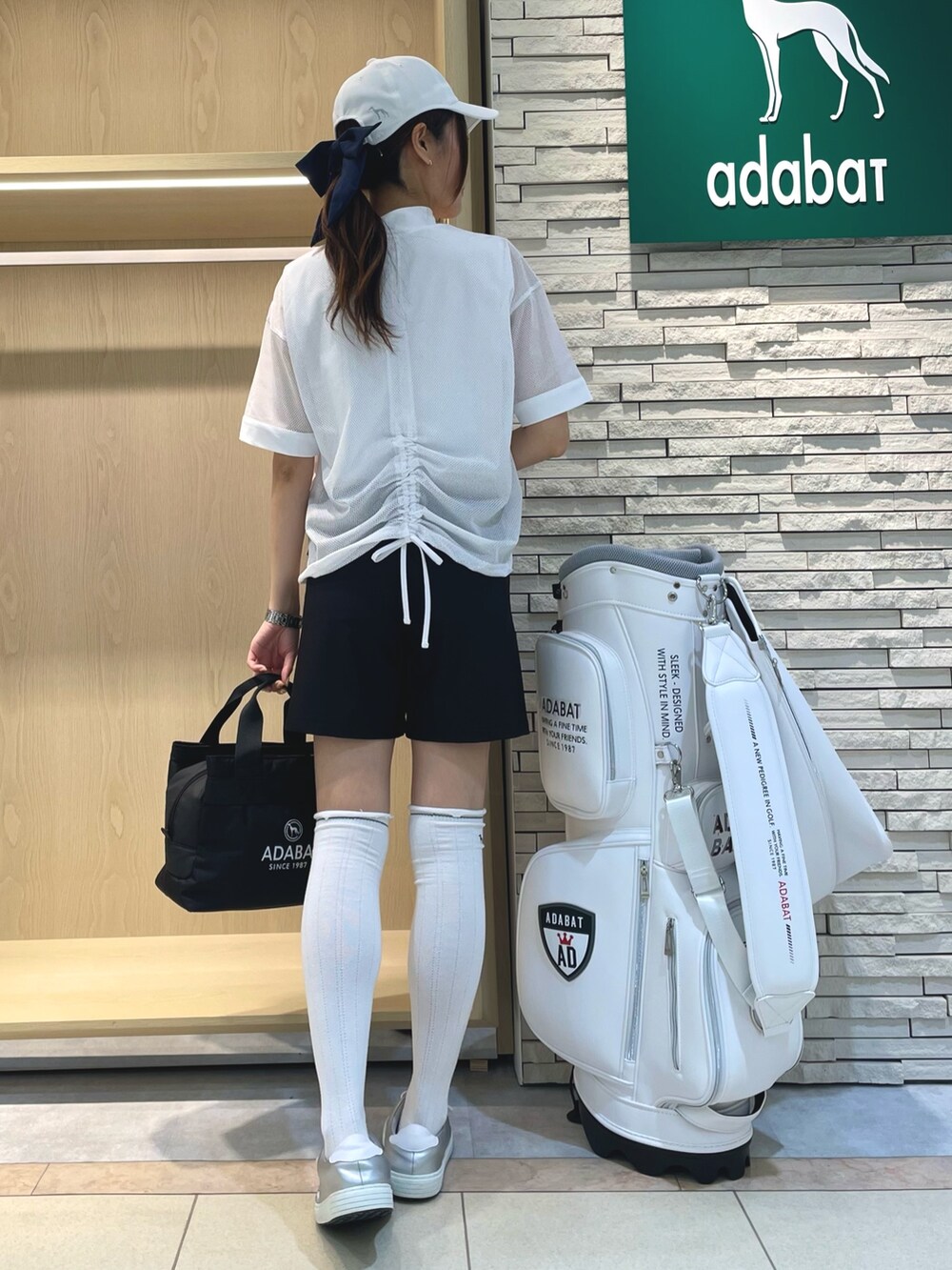 ホワイト系のTシャツ/カットソー、ブラック系のその他パンツ、ホワイト系のキャップを着用したレディースの春コーディネートの3枚目の写真