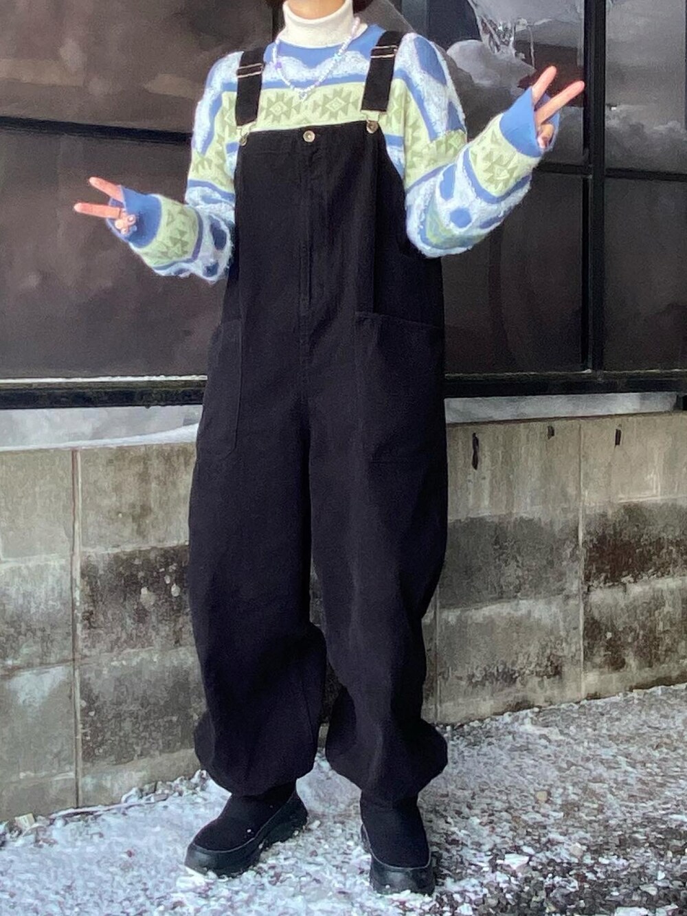 その他のニット/セーター、ブラック系のサロペット/オーバーオール、ブラック系のブーツを着用したレディースの冬コーディネートの2枚目の写真