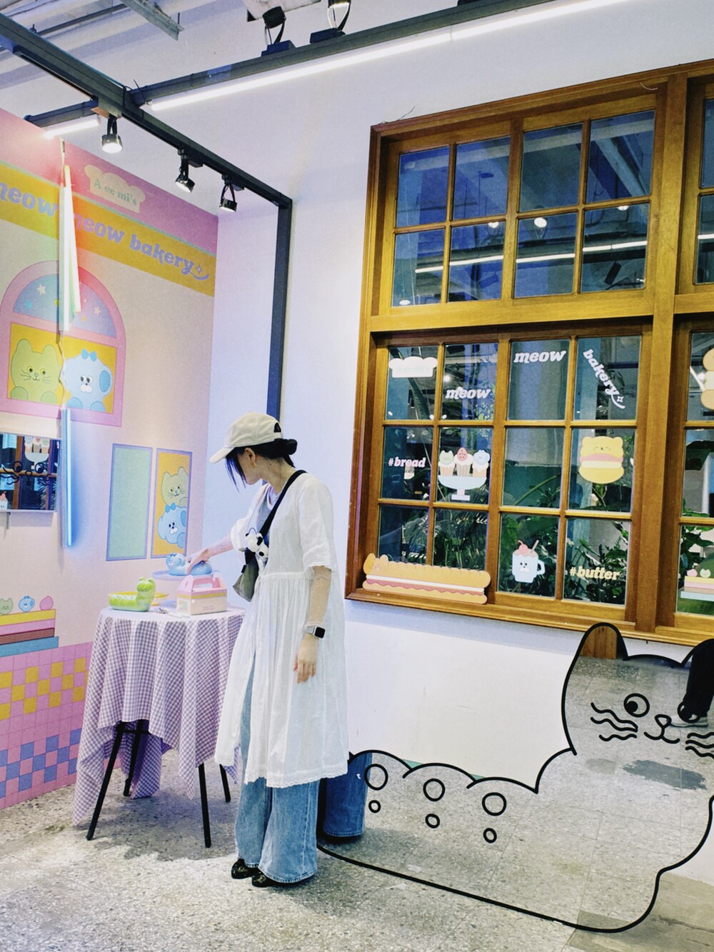 ホワイト系のノーカラージャケット、ブルー系のデニムパンツ、グリーン系のショルダーバッグを着用したレディースの秋コーディネートの2枚目の写真