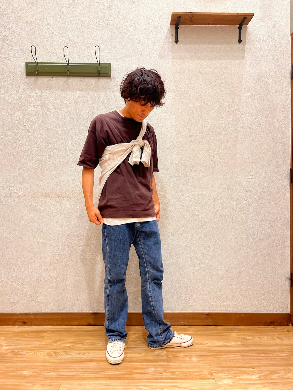 ブルー系のデニムパンツ、ホワイト系のスニーカー、ブラウン系のTシャツ/カットソーを着用したメンズの夏コーディネートの2枚目の写真