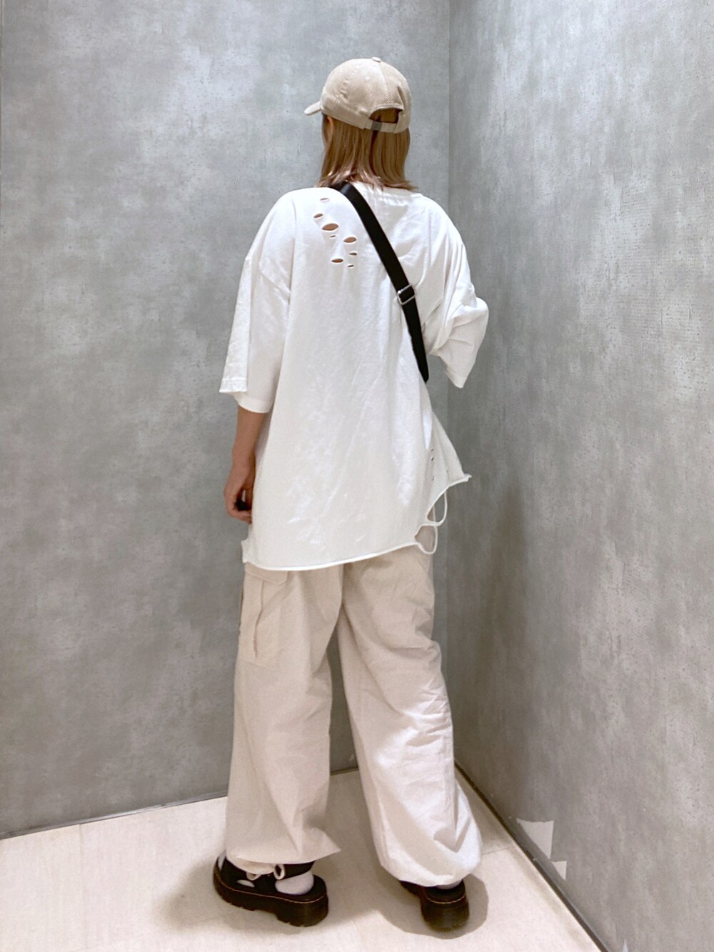 ホワイト系のカーゴパンツ、ホワイト系のTシャツ/カットソー、グリーン系のショルダーバッグを着用したレディースの春コーディネートの2枚目の写真