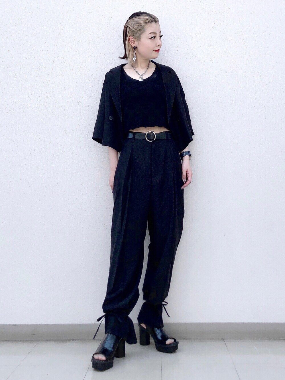 ブラック系のタンクトップ、ブラック系のテーラードジャケット、ブラック系のスラックスを着用したレディースの夏コーディネートの3枚目の写真