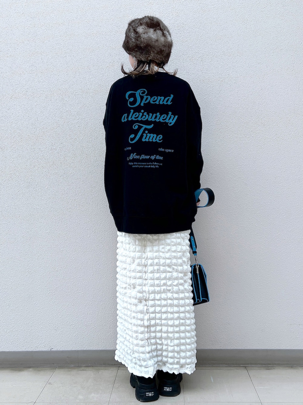 ブラック系のスウェット、ホワイト系のTシャツ/カットソー、ホワイト系のスカートを着用したレディースの冬コーディネートの2枚目の写真