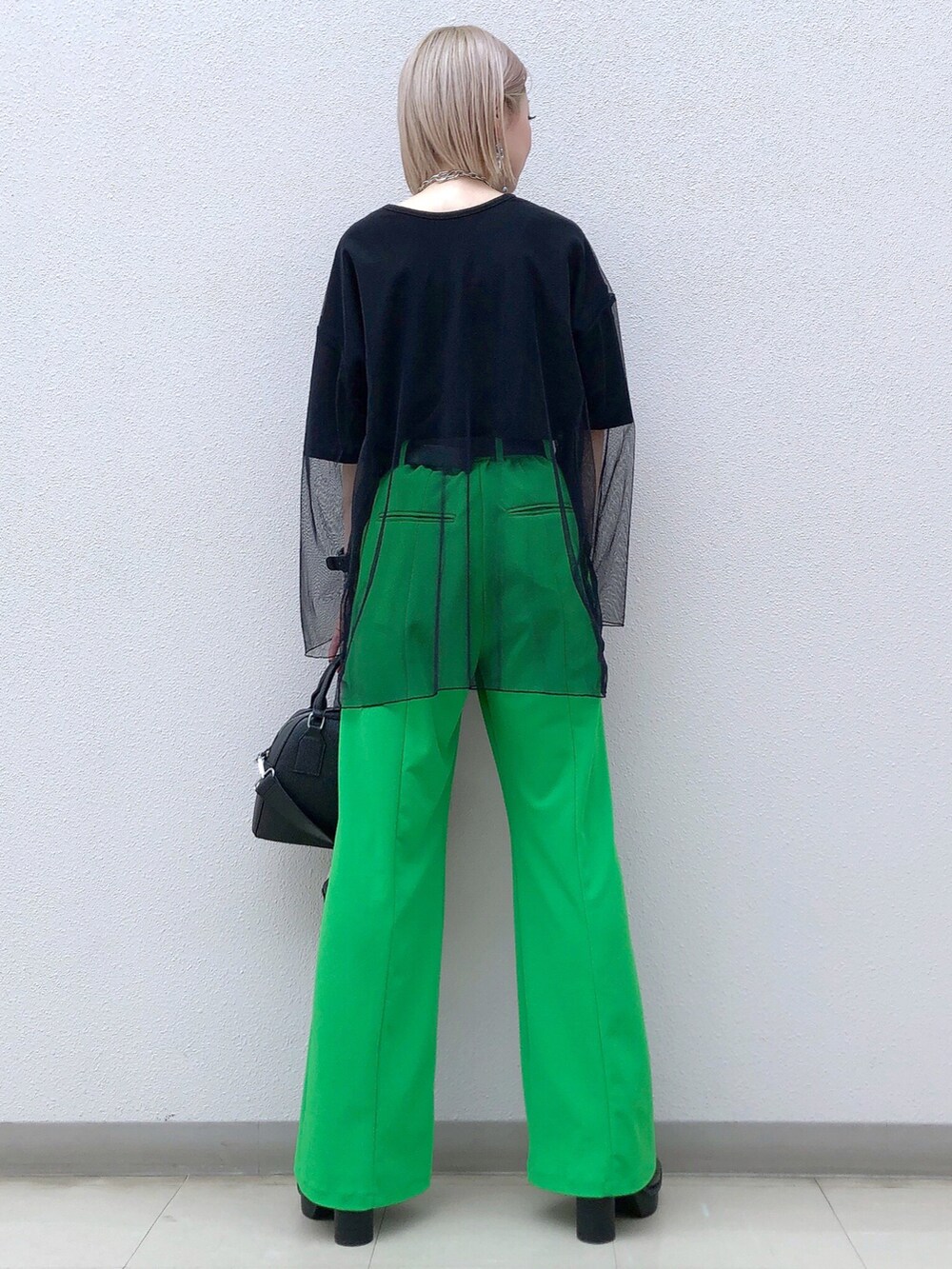 ブラック系のTシャツ/カットソー、グリーン系のその他パンツ、ブラック系のショルダーバッグを着用したレディースの春コーディネートの4枚目の写真