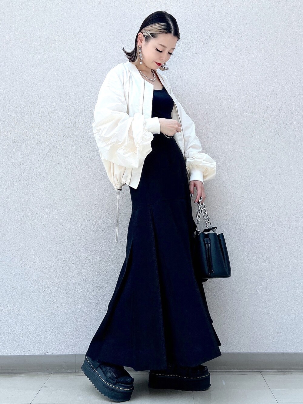 ホワイト系のMA-1、ブラック系のスカート、ブラック系のショルダーバッグを着用したレディースの夏コーディネートの2枚目の写真