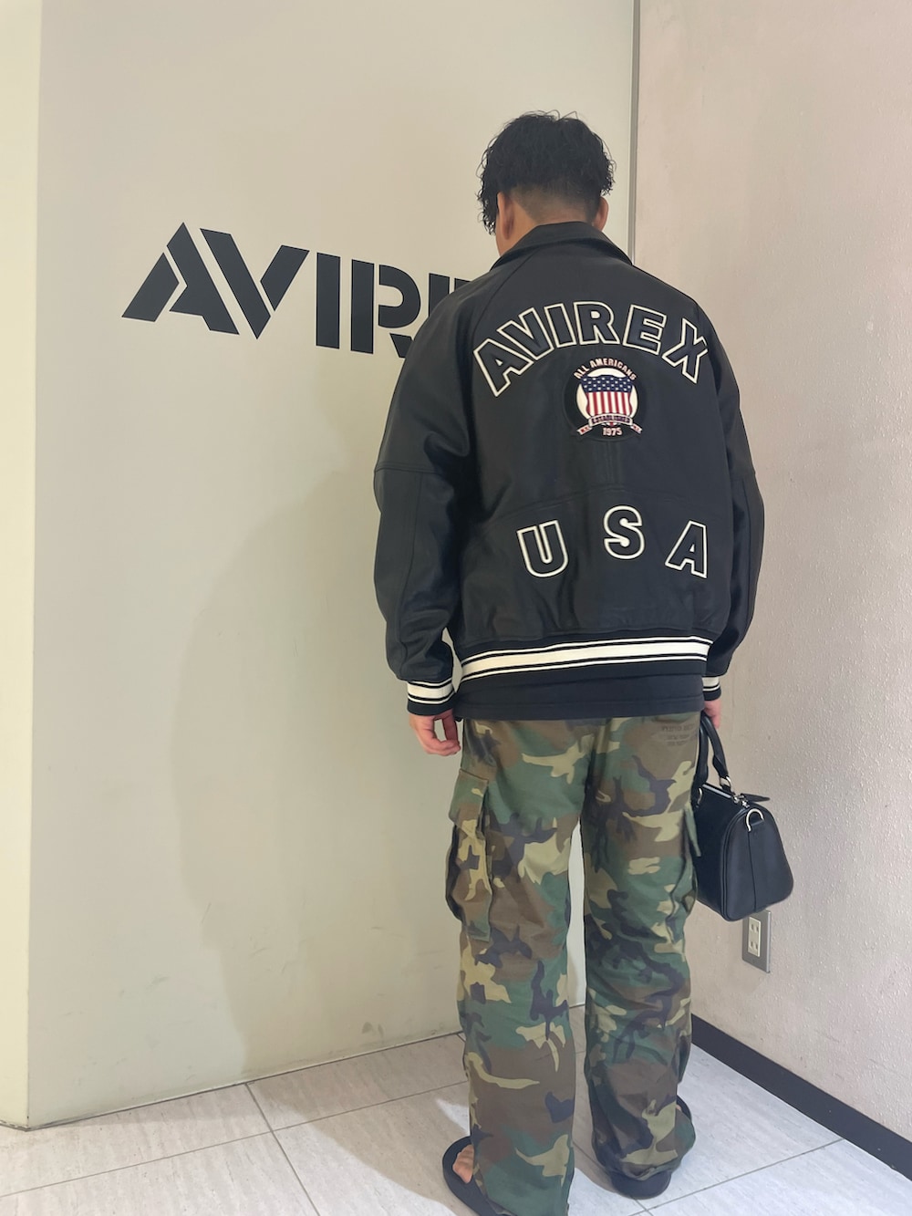 「ロゴT、ブラック、ブラックコーデ、AVIREX、サンダル、ootd、夏コーデ、いいね、save、フォローお願いします🤑、iTTi、ファッションの力を信じよう」｜「AVIREXのLIGHT SIGNATURE VARSITY JACKET / ライト シグネチャー バーシティ ジャケット / AVIREX / アヴィレックス（スタジャン、ブラック系）」を使った、Yu OTSUKAさん（メンズ・176cm）の夏コーディネートの2枚目の写真