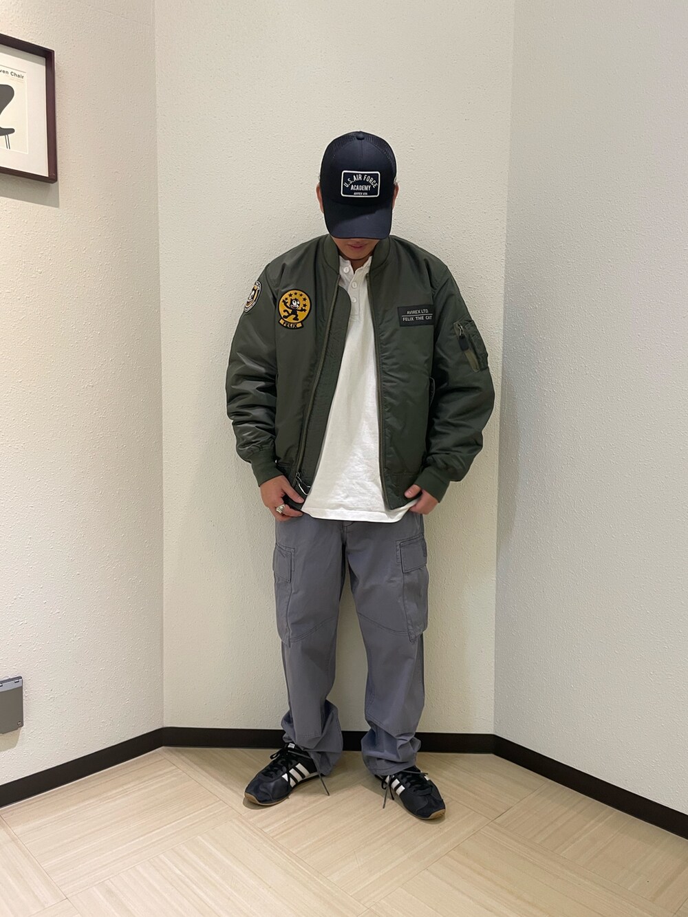 グレー系のカーゴパンツ、グリーン系のMA-1、ブラック系のキャップを着用したメンズの冬コーディネートの2枚目の写真