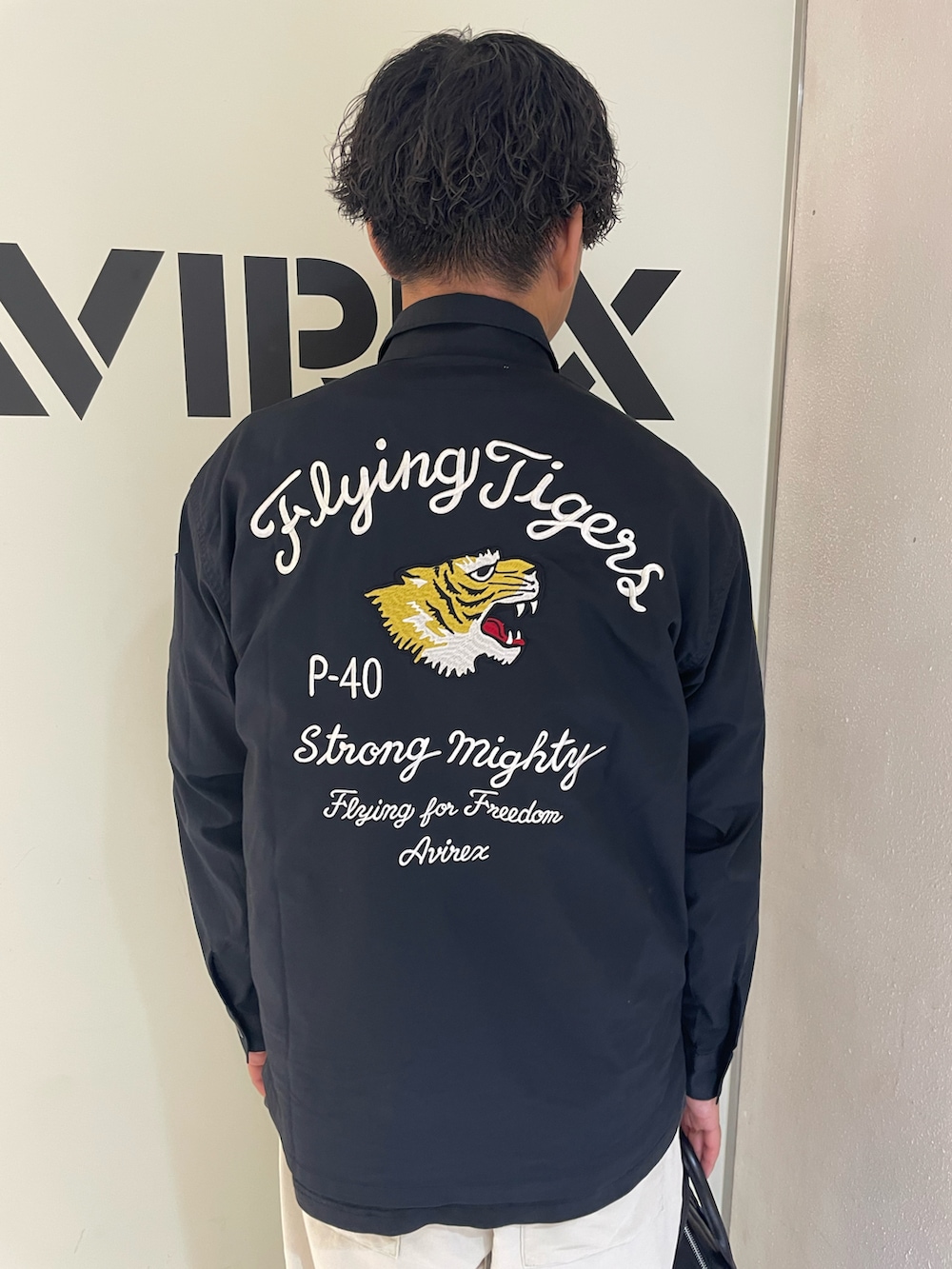 ブラック系のシャツ/ブラウス、ホワイト系のTシャツ/カットソー、ベージュ系のパンツを着用したメンズの夏コーディネートの3枚目の写真