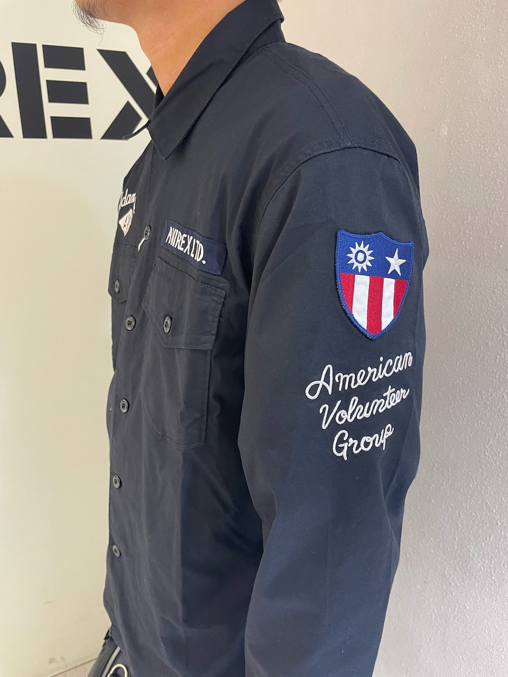 ブラック系のシャツ/ブラウス、ホワイト系のTシャツ/カットソー、ベージュ系のパンツを着用したメンズの夏コーディネートの4枚目の写真