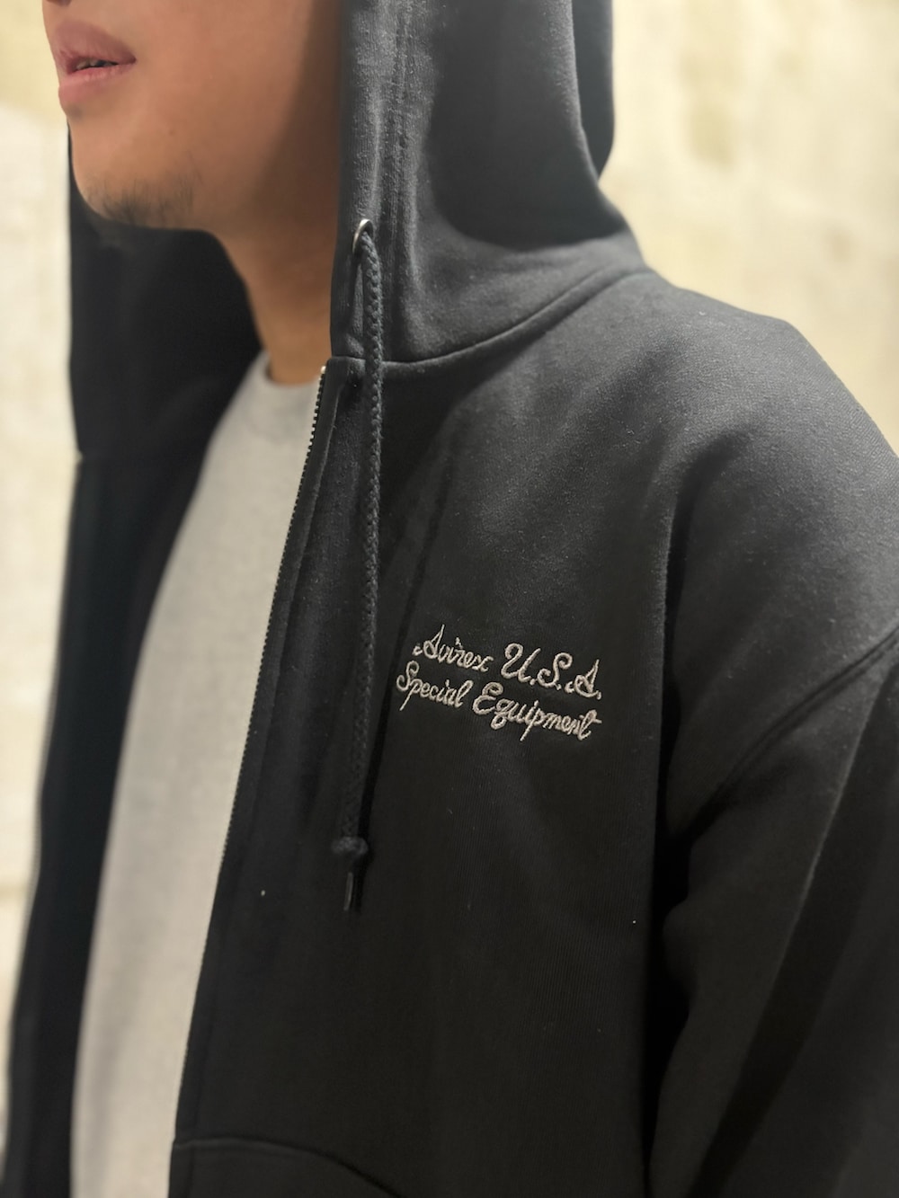 ブラック系のパーカー、ホワイト系のTシャツ/カットソー、ブラック系のスウェットパンツを着用したメンズの春コーディネートの3枚目の写真