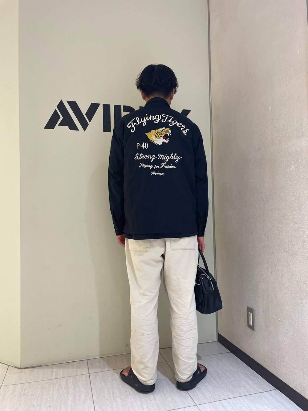 ブラック系のシャツ/ブラウス、ホワイト系のTシャツ/カットソー、ベージュ系のパンツを着用したメンズの夏コーディネートの2枚目の写真