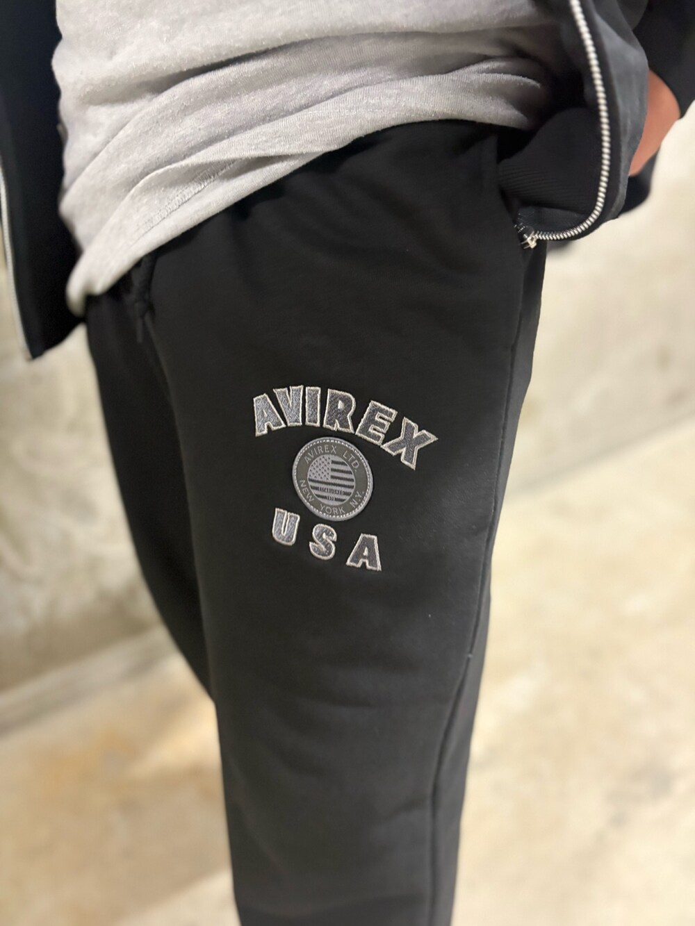 ブラック系のパーカー、ホワイト系のTシャツ/カットソー、ブラック系のスウェットパンツを着用したメンズの春コーディネートの4枚目の写真