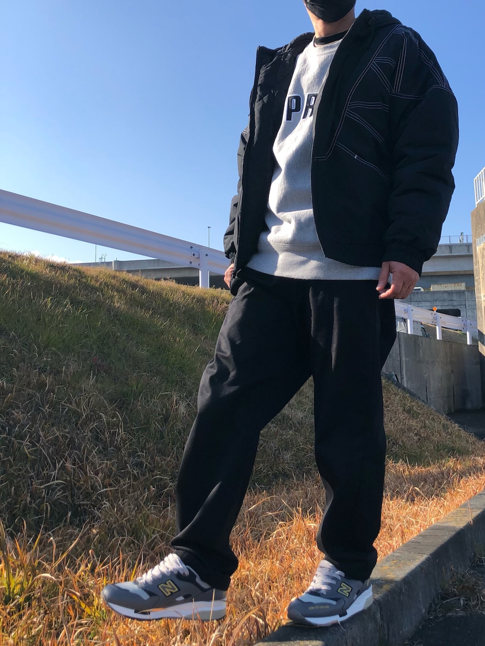 ブラック系のブルゾン、グレー系のスウェット、ブラック系のチノパンツを着用したメンズの冬コーディネートの3枚目の写真