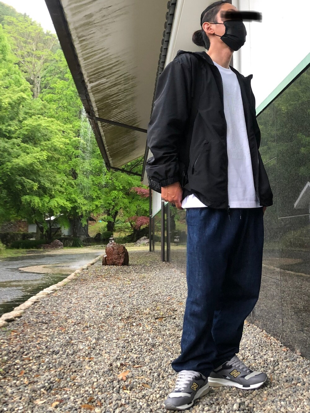 ブルー系のその他パンツ、ブラック系のナイロンジャケット、ブラック系のショルダーバッグを着用したメンズの春コーディネートの2枚目の写真