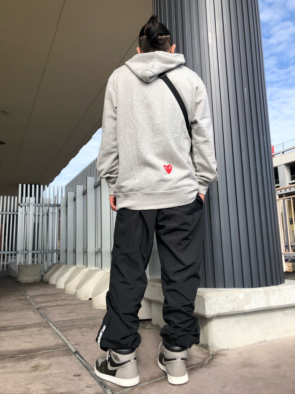 グレー系のパーカー、ブラック系のショルダーバッグ、ブラック系のその他パンツを着用したメンズの春コーディネートの4枚目の写真