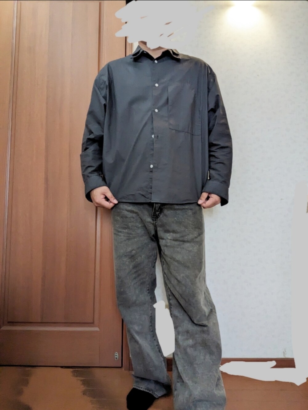 ブラック系のダウンジャケット/コート、ブラック系のショルダーバッグ、グレー系のデニムパンツを着用したメンズの冬コーディネートの2枚目の写真