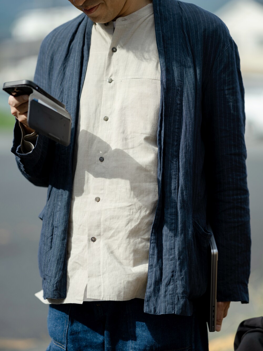 ブルー系のジャケット/アウター、ベージュ系のシャツ/ブラウス、ブルー系のデニムパンツを着用したメンズの秋コーディネートの3枚目の写真