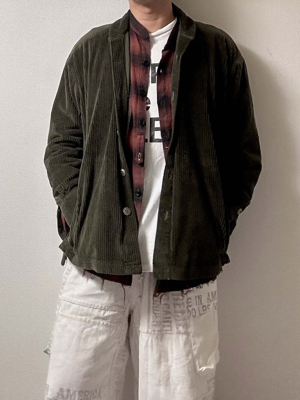 グリーン系のミリタリージャケット、レッド系のシャツ/ブラウス、ホワイト系のTシャツ/カットソーを着用したレディースの秋コーディネートの4枚目の写真