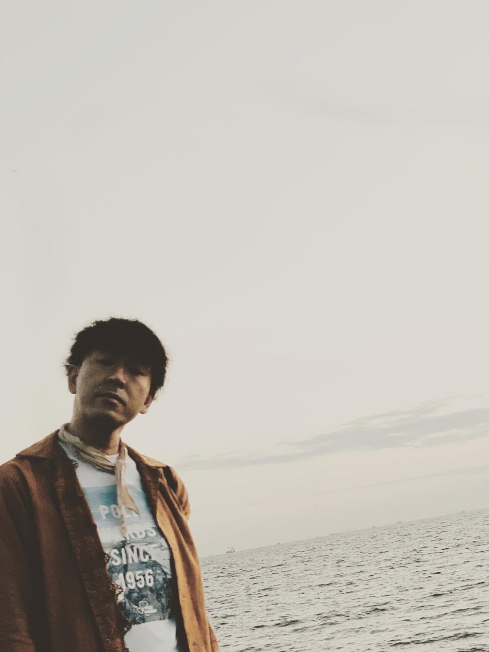 ホワイト系のTシャツ/カットソー、ブラウン系のシャツ/ブラウス、ホワイト系のスニーカーを着用したメンズの夏コーディネートの3枚目の写真