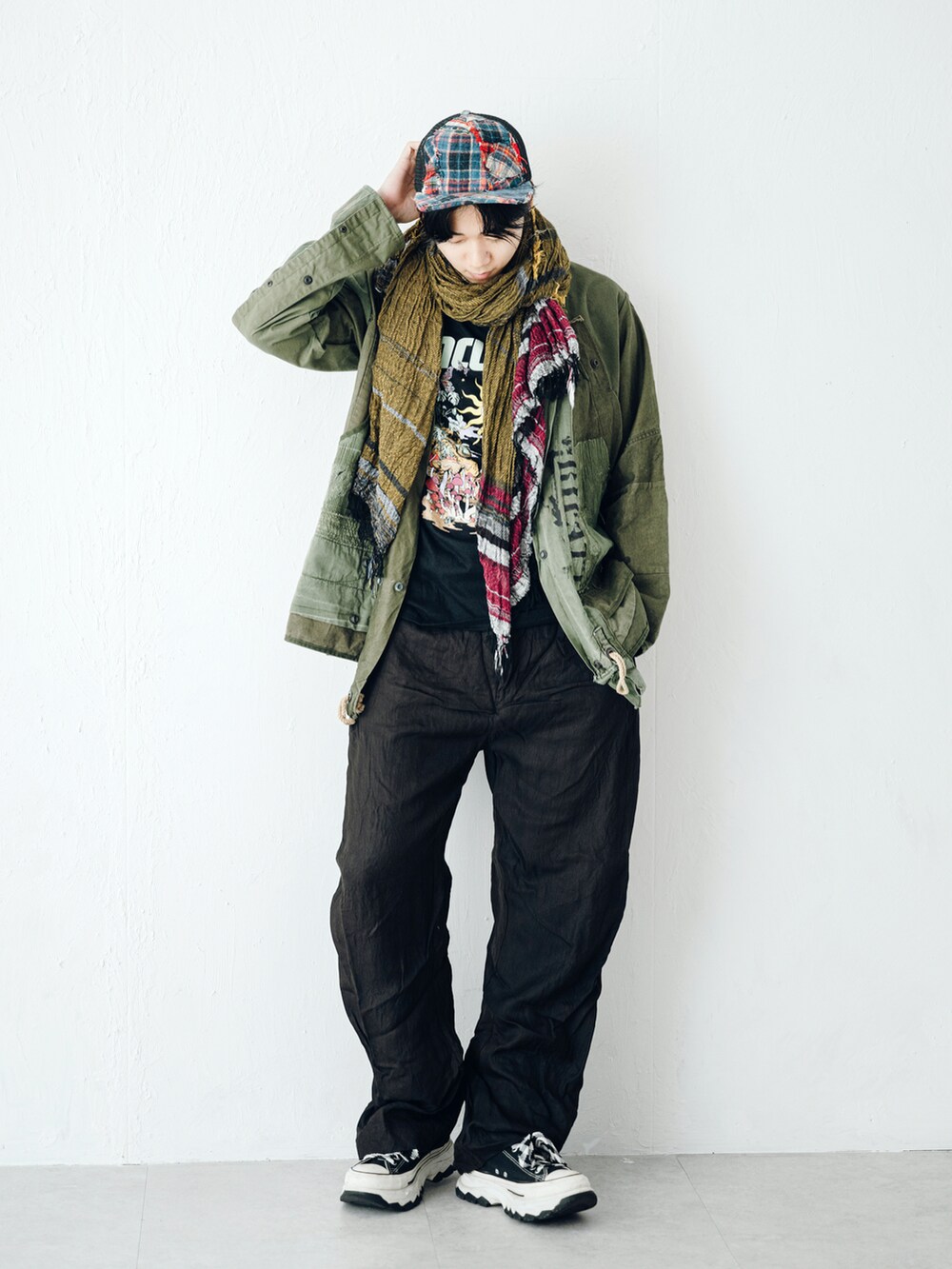 ブラック系のカーゴパンツ、グリーン系のミリタリージャケット、ブラック系のTシャツ/カットソーを着用したメンズの秋コーディネートの2枚目の写真