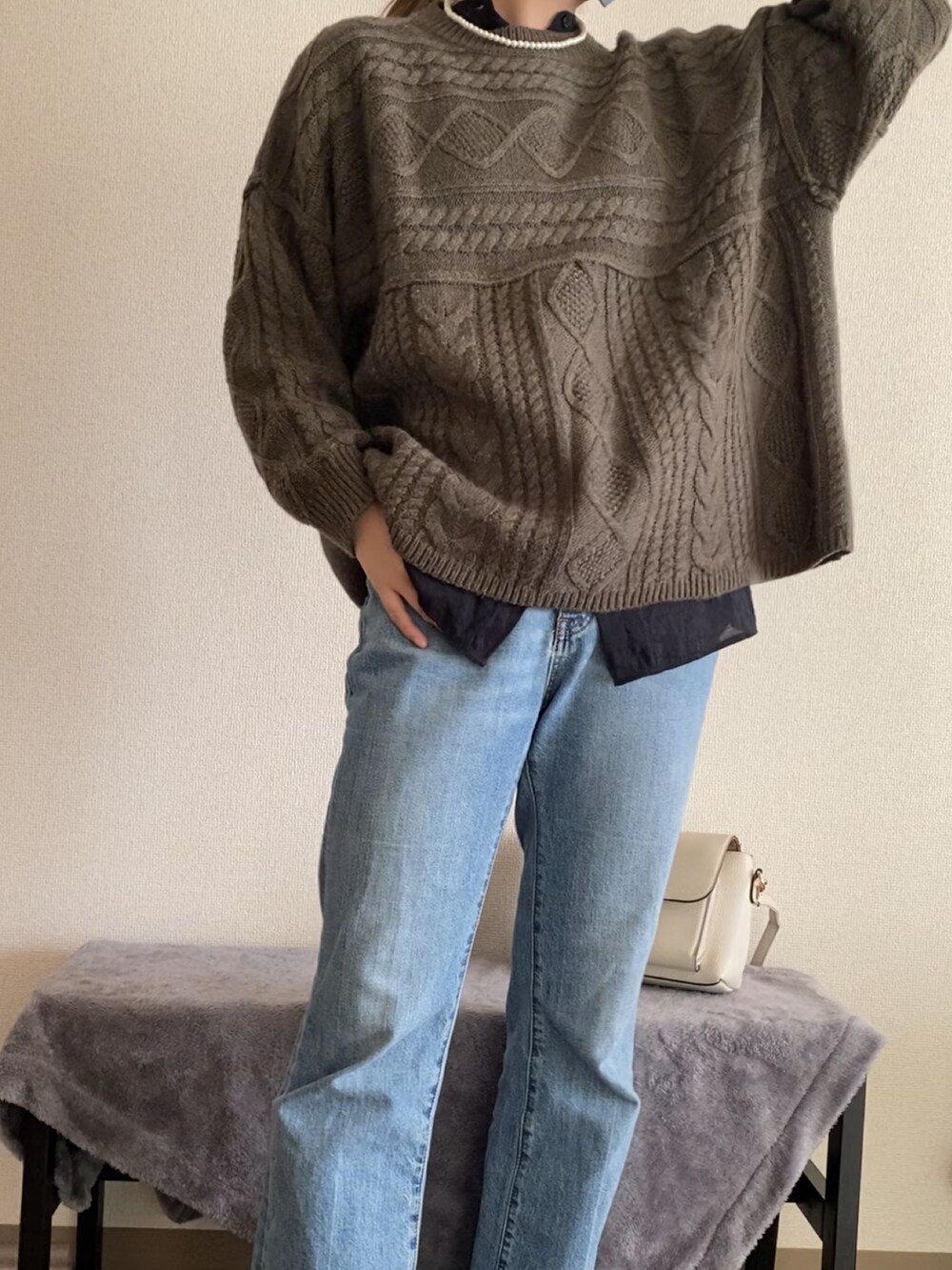 ブルー系のデニムパンツ、ホワイト系のブーツ、グリーン系のニット/セーターを着用したレディースの冬コーディネートの4枚目の写真