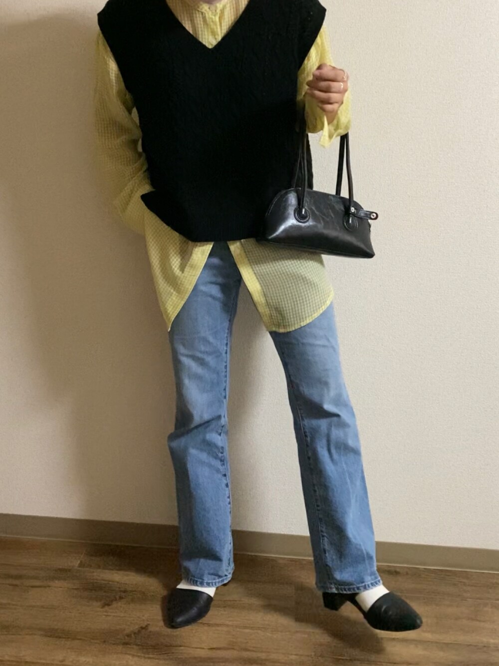 ブルー系のデニムパンツ、シルバー系のパンプス、ブラック系のパンプスを着用したレディースの秋コーディネートの4枚目の写真