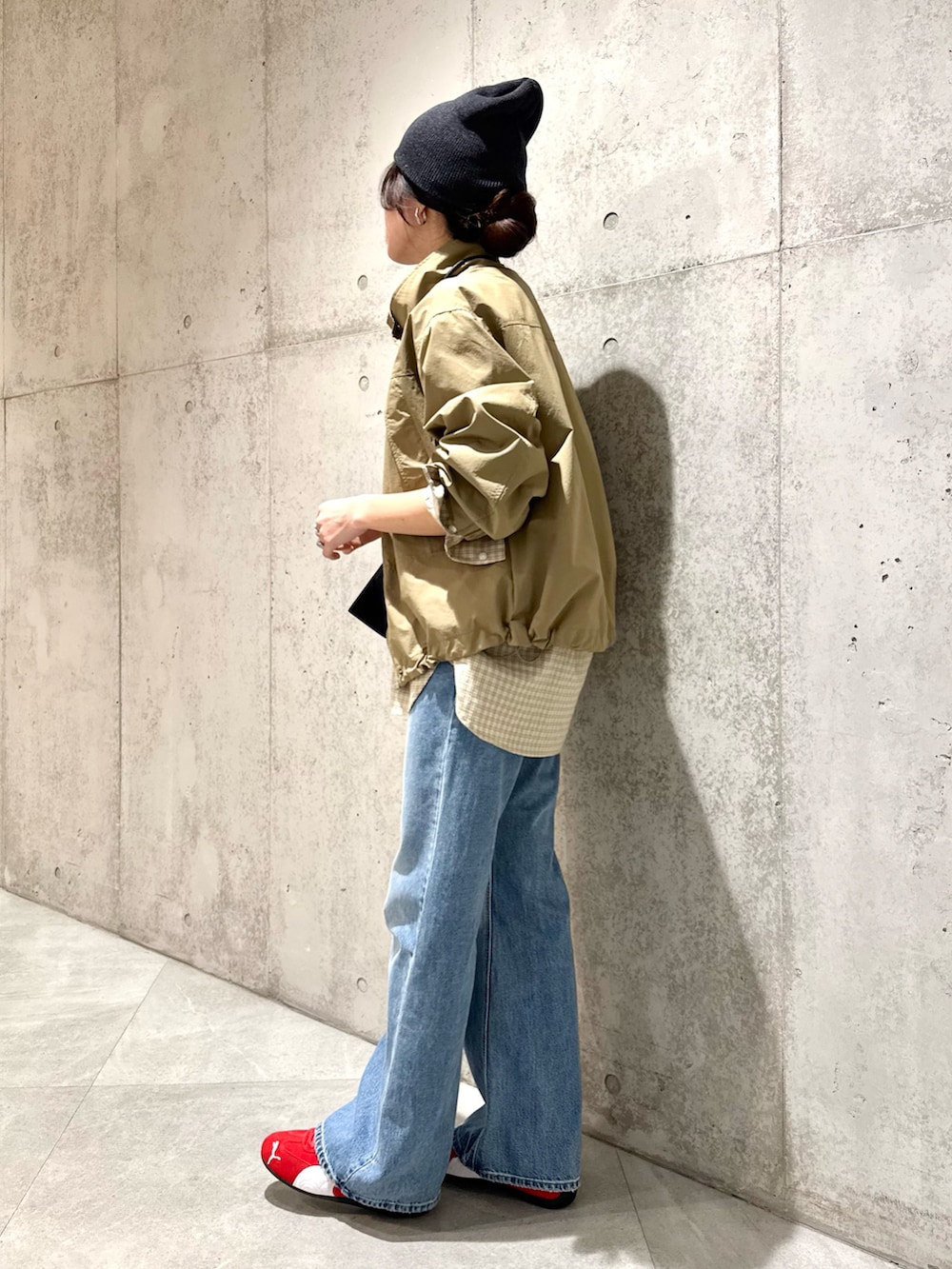 ベージュ系のナイロンジャケット、ブラウン系のスニーカー、ブラック系のショルダーバッグを着用したレディースの春コーディネートの6枚目の写真