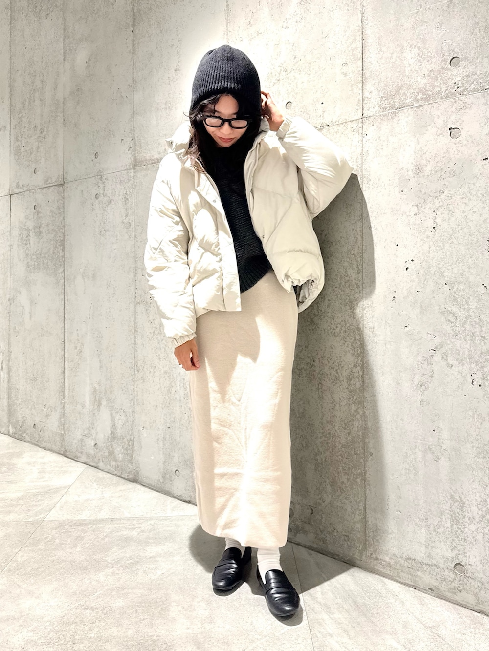 ホワイト系のスカート、グリーン系のニット/セーター、ホワイト系のダウンジャケット/コートを着用したレディースの秋コーディネートの2枚目の写真