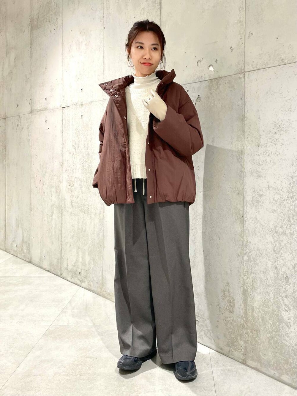 ブラウン系のブルゾン、ホワイト系のTシャツ/カットソー、ホワイト系のニット/セーターを着用したレディースの冬コーディネートの3枚目の写真