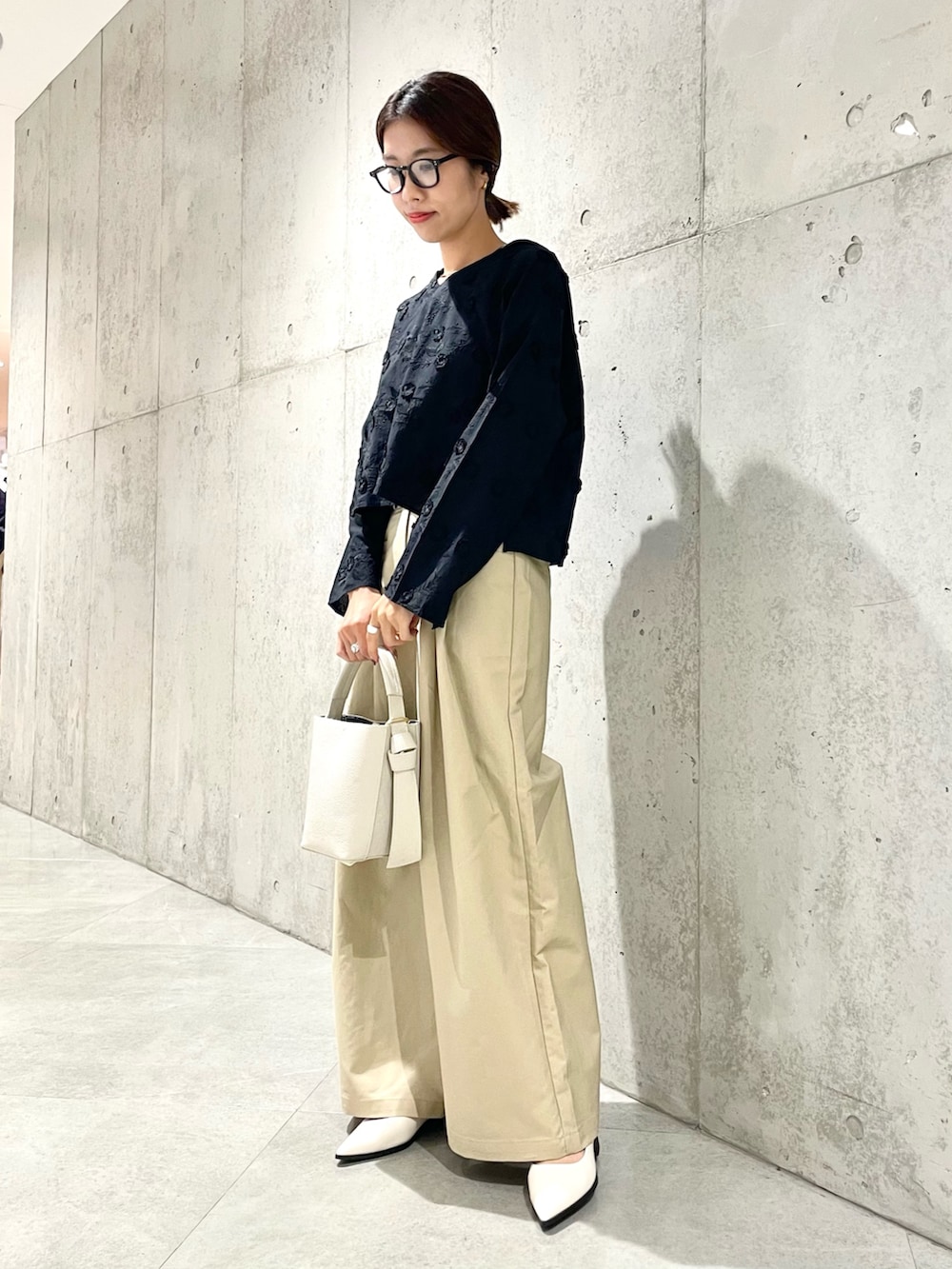 ベージュ系のショルダーバッグ、ホワイト系のその他シューズ、ブラック系のシャツ/ブラウスを着用したレディースの秋コーディネートの2枚目の写真