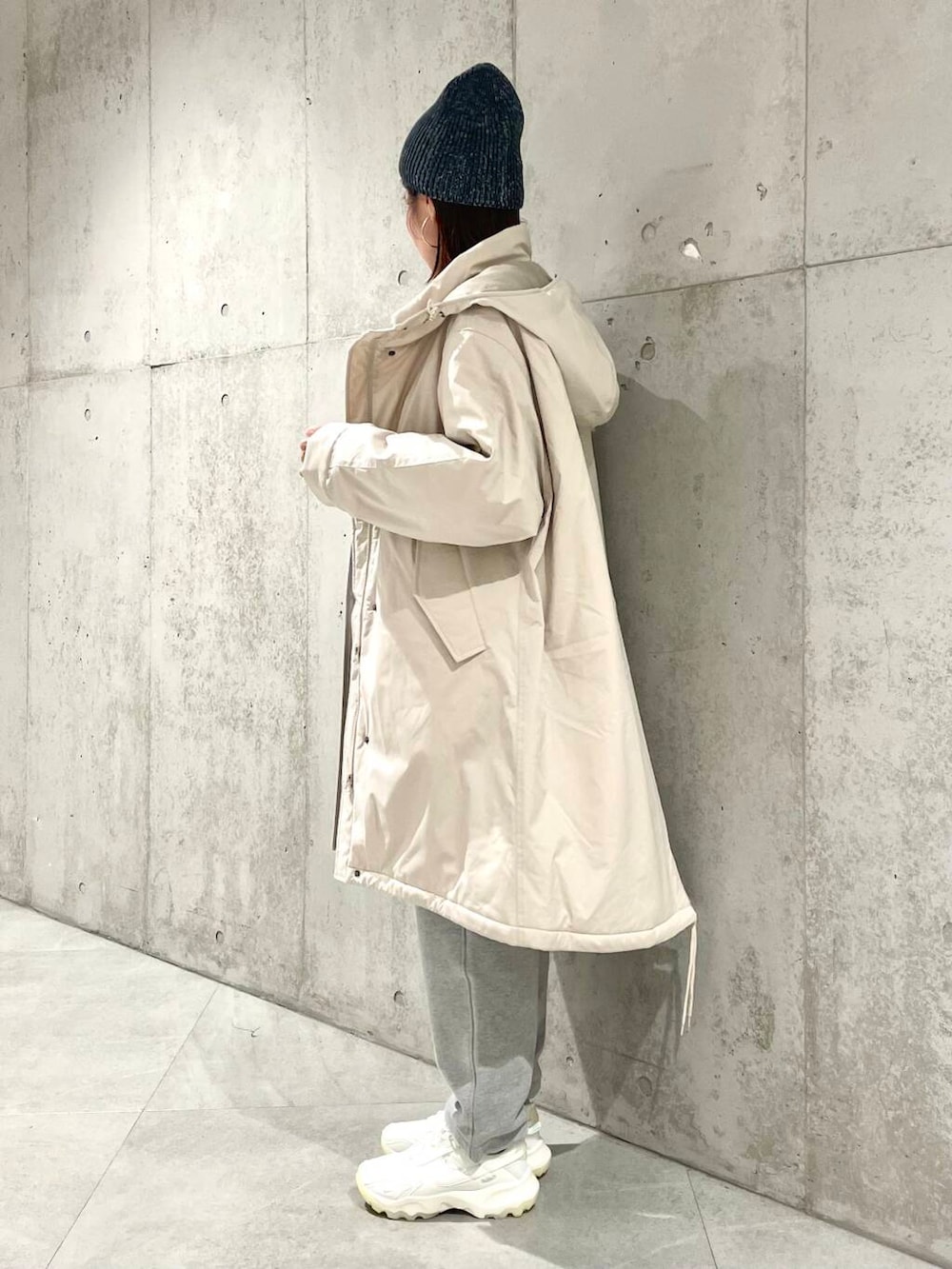 ホワイト系のスニーカー、ベージュ系のダウンジャケット/コート、ブルー系のニット/セーターを着用したレディースの冬コーディネートの3枚目の写真