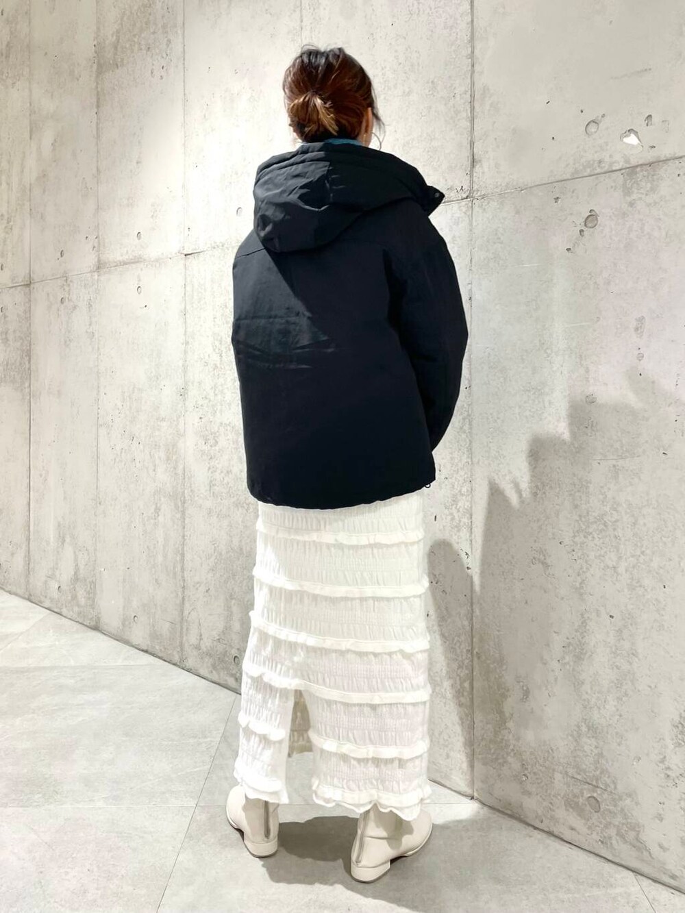 ブラック系のダウンジャケット/コート、グレー系のスウェット、ホワイト系のスカートを着用したレディースの秋コーディネートの3枚目の写真