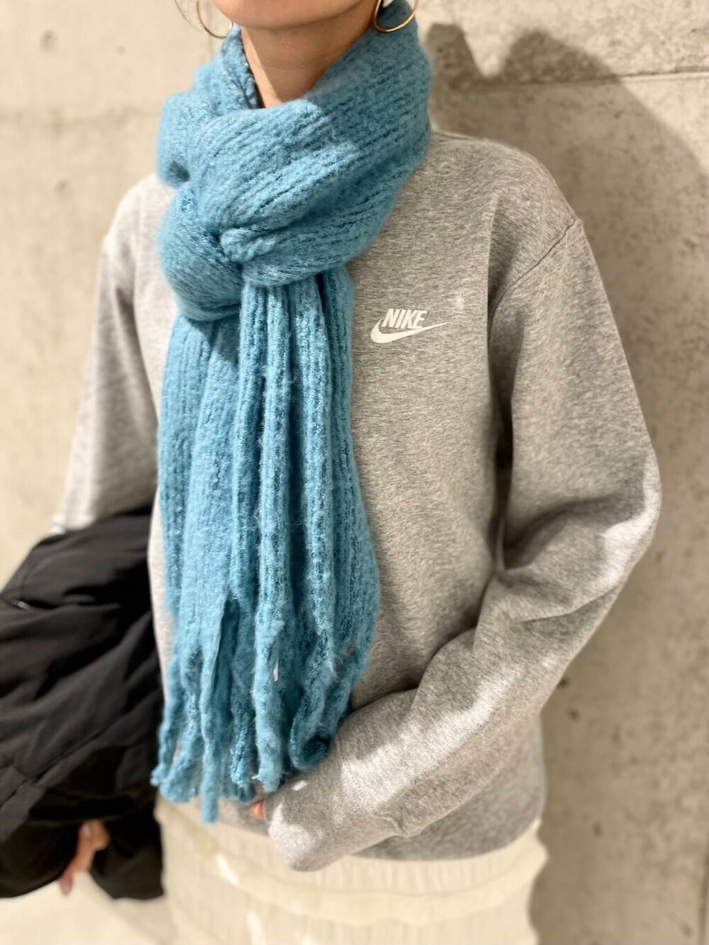 ブラック系のダウンジャケット/コート、グレー系のスウェット、ホワイト系のスカートを着用したレディースの秋コーディネートの6枚目の写真