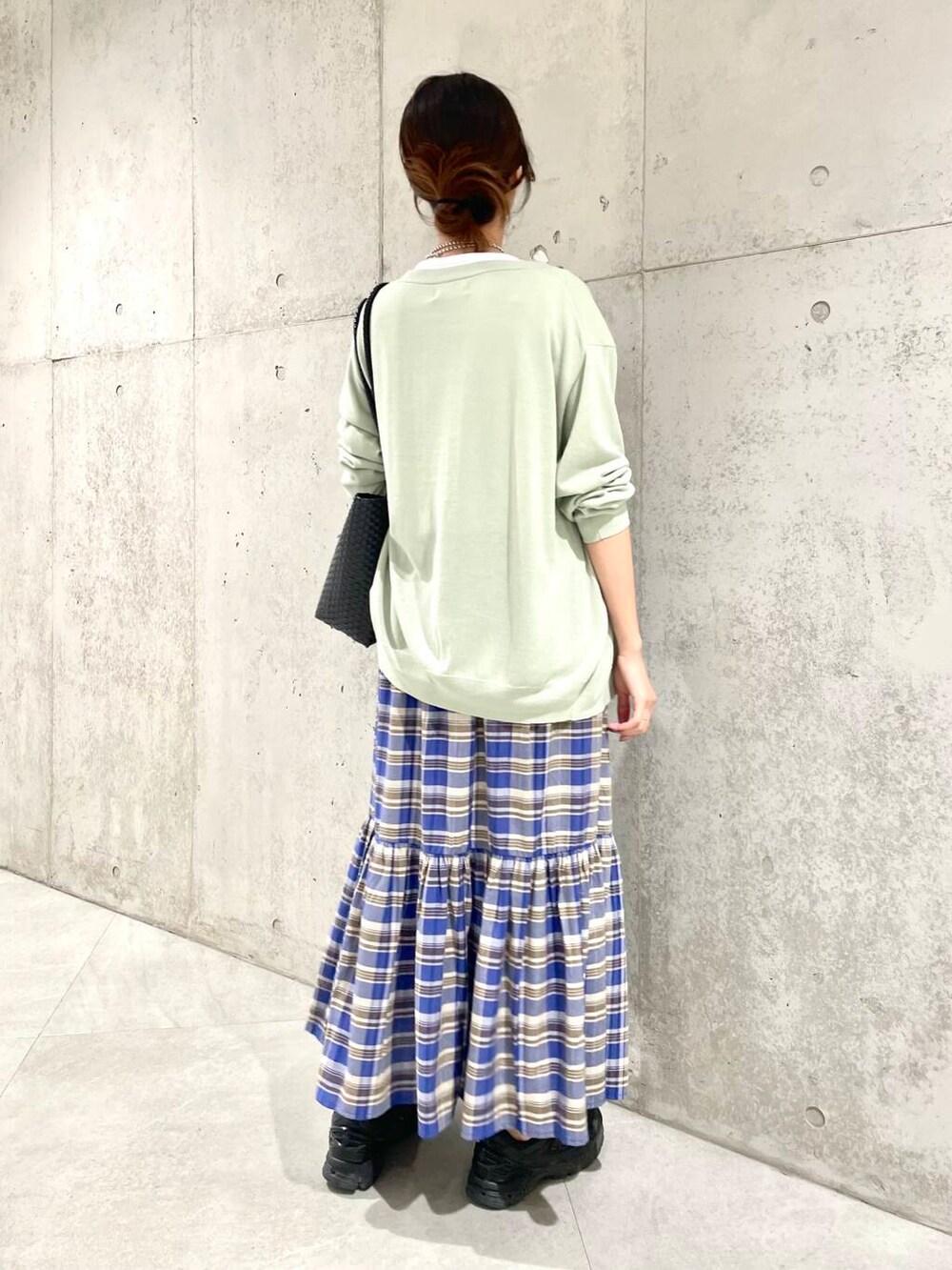 グリーン系のカーディガン/ボレロ、ホワイト系のTシャツ/カットソー、ブラック系のトートバッグを着用したレディースの春コーディネートの4枚目の写真