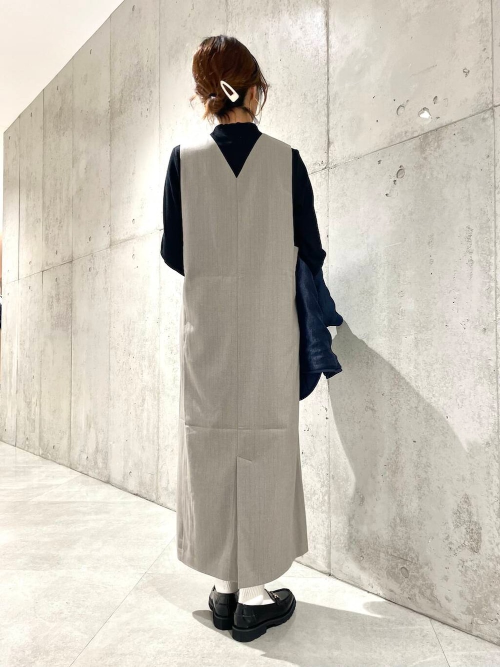 ブラック系のTシャツ/カットソー、ベージュ系のワンピース、ブラック系のローファーを着用したレディースの秋コーディネートの5枚目の写真