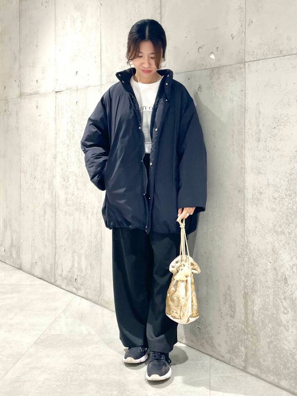 ブラック系のブルゾン、ブラック系のその他パンツ、ホワイト系のTシャツ/カットソーを着用したレディースの秋コーディネートの2枚目の写真